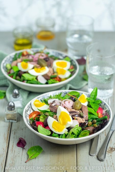 Zwei Teller mit Salat Thunfisch Ei Rezept