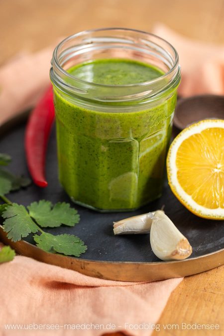 Ein Glas mit Koriander-Zitronen-Sauce als Topping