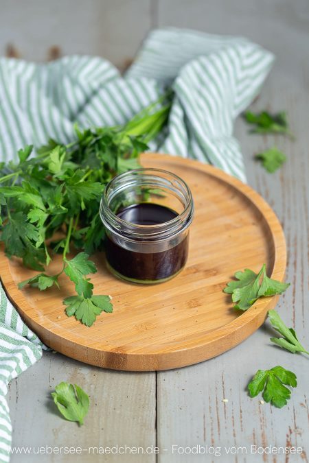 Glas mit grünem Öl Kräuteröl aus Petersilie und Sonnenblumenöl